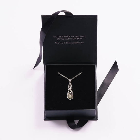 A silver pendant necklace with Connemara Marble displayed in an elegant black jewelry box. The box features a message on the inside lid that reads, “A little piece of Ireland especially for you.”