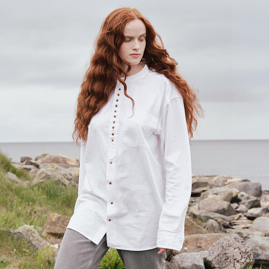 Image featuring the Classic Grandad Shirt in white, crafted with a traditional Irish grandad collar, button-front placket, and relaxed fit silhouette, showcasing timeless Irish style against a scenic coastal backdrop.