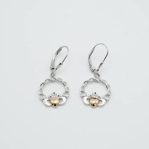 Pair of silver and gold claddagh earrings on a light gray background