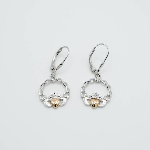 Pair of silver and gold claddagh earrings on a light gray background
