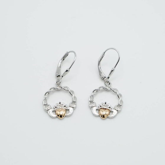 Pair of silver and gold claddagh earrings on a light gray background