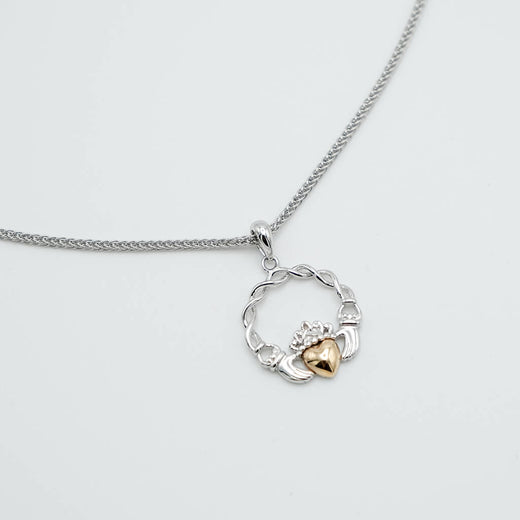 Necklace with a silver claddagh pendant on a light gray background