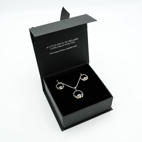 Black jewelry box with silver earrings inside on a white background