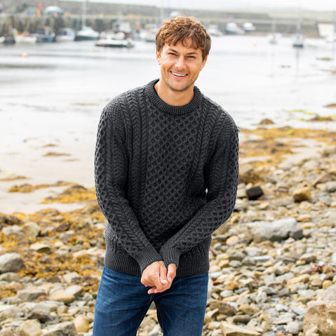 Men's traditional charcoal grey crew neck Aran sweater, crafted from authentic Irish wool with classic cable knit patterns