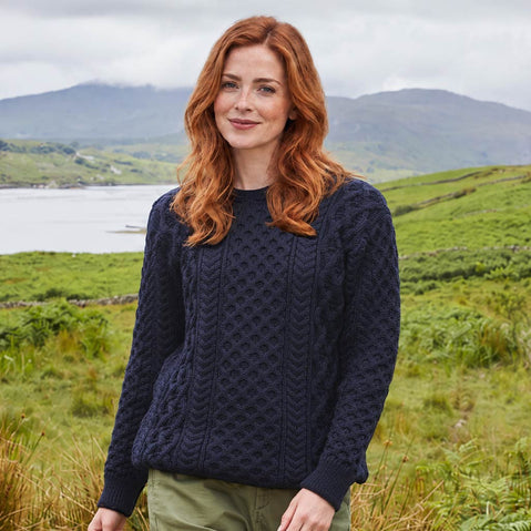 Image featuring the Women's Crew Neck Irish Wool Classic Sweater in navy, crafted from premium Irish wool with traditional cable knit patterns and a timeless crew neck silhouette, showcasing classic Irish craftsmanship against a rugged countryside setting.