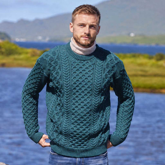 Image featuring the Men's Crew Neck Irish Wool Classic Sweater in green, crafted from premium Irish wool with traditional cable knit patterns and a timeless crew neck silhouette, showcasing classic Irish craftsmanship against a scenic lakeside landscape.