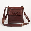 A brown leather shoulder bag with embossed Celtic knotwork, featuring a front zipper pocket and a adjustable strap, displayed against a white background.