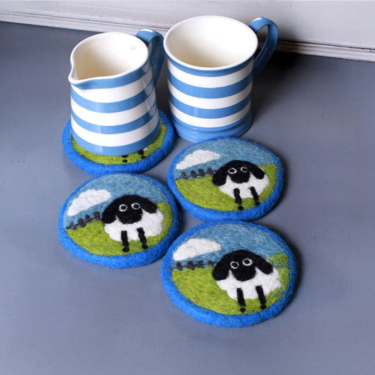 Set of coasters with sheep design on a blue surface with striped mugs.
