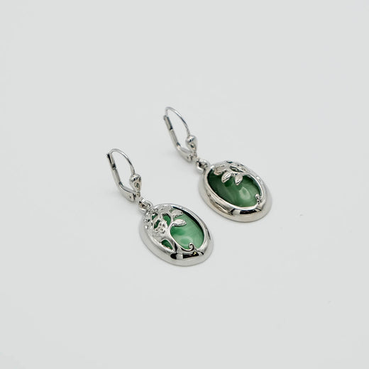 Pair of silver earrings with green gemstones on a white background