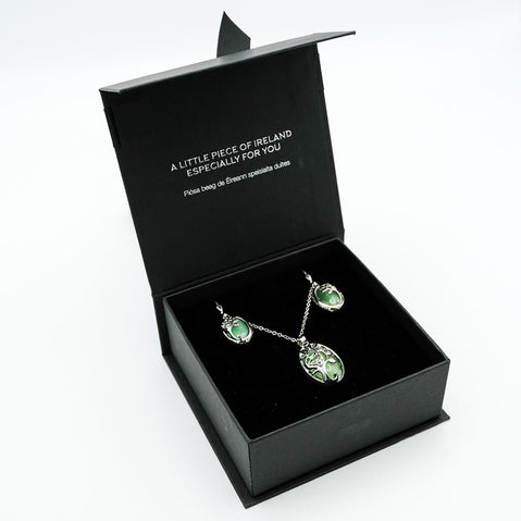 Green gemstone jewelry set in a black box with text on a white background