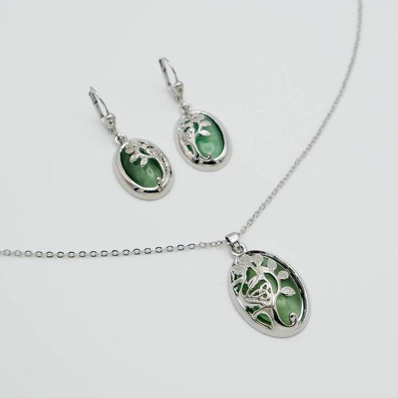 Jewelry set with green pendant and silver chain on a white background