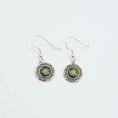 Pair of silver earrings with green stones on a white background