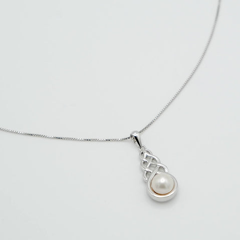 Silver necklace with a pearl pendant on a light gray background