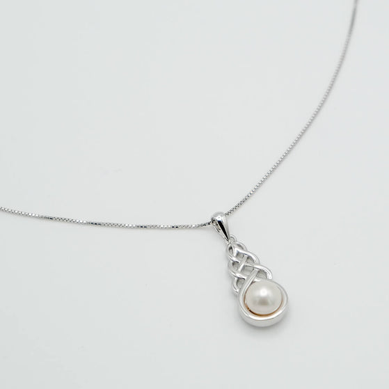 Silver necklace with a pearl pendant on a light gray background