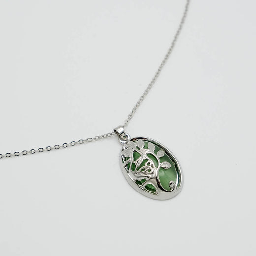 Silver necklace with a green pendant on a light gray background