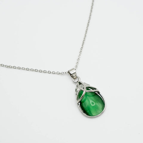Green teardrop pendant on a silver chain against a white background