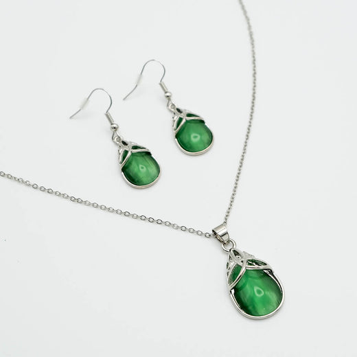 Jewelry set with green teardrop-shaped stones on a white background