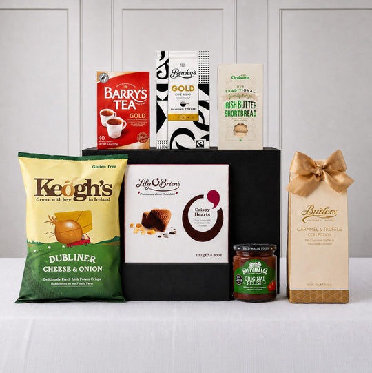 The Emerald Isle Gourmet Collection gift hamper featuring Barry's Tea Gold Blend, Bewley's Gold Coffee, Keogh's Dubliner Cheese & Onion Crisps, Irish butter shortbread, Lily O'Brien's chocolates, Butlers truffles, and Ballymaloe Original Relish.