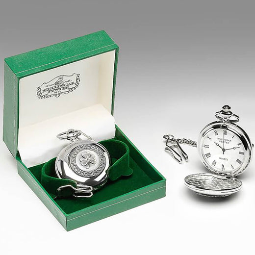 Silver pocket watch with shamrock design in a green box on a gray background