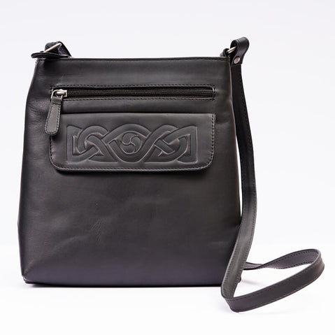 A black leather shoulder bag with embossed Celtic knotwork on the front and a visible zipper pocket. It has a single shoulder strap and a main compartment.