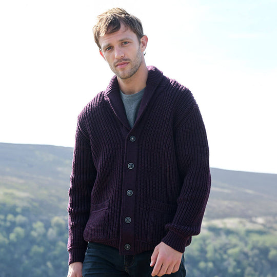 Man wearing a dark purple Aran cardigan with a scenic background