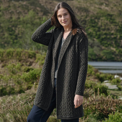 Woman wearing an army green knitted coat outdoors with a natural background