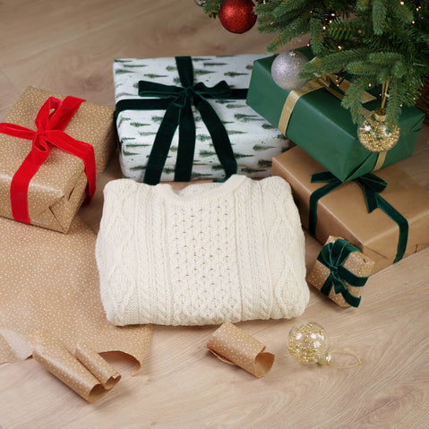 Fisherman Lightweight Crew Neck Heritage Sweater in white with traditional honeycomb cable knit pattern, displayed with wrapped Christmas gifts under a decorated tree