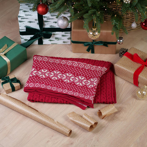 Festive red Aran Christmas throw with traditional honeycomb stitch pattern and snowflake trim, perfect for holiday decorating