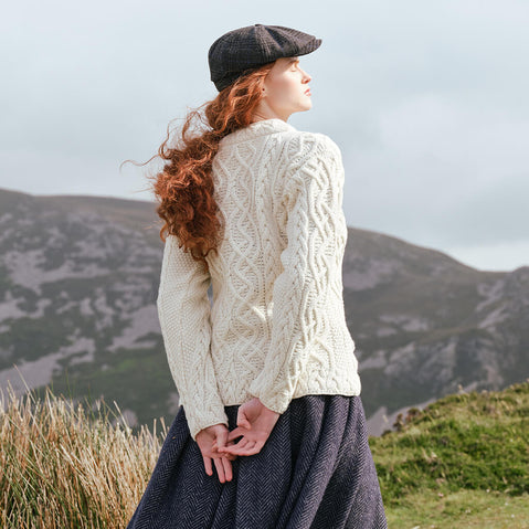 Image featuring the Women's Cable Knit Aran Tunic Sweater in natural cream, crafted with authentic Irish Aran cable knit patterns and an elegant tunic silhouette, inspired by Ireland's rich knitting heritage and scenic countryside.