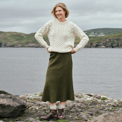 Irish Tweed Fleck A-Line Skirt in green, crafted from authentic Irish tweed with subtle multicolored flecks and a flattering A-line silhouette, showcased against Ireland's rugged coastline and countryside.