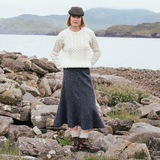 Image featuring the Irish Tweed Fleck A-Line Skirt in navy, crafted from authentic Irish flecked tweed with a flattering A-line shape, showcasing timeless Irish heritage style in a rugged coastal setting.