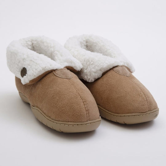 A pair of men's cozy slippers in a mink color with faux sheepskin lining, worn with red plaid pajama pants.