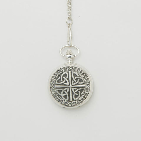 Silver mechanical pocket watch featuring an engraved Trinity knot design on the front, hanging from a matching chain against a light background.