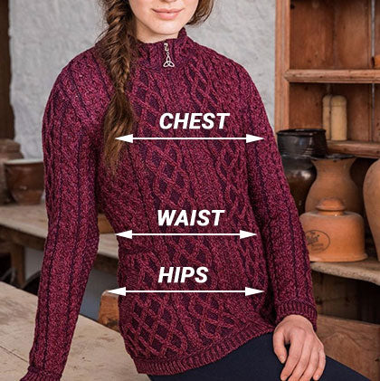 A woman in a burgundy aran sweater with a high collar stands against a rustic wooden backdrop. The sweater features a textured cable knit pattern, and text labels indicate