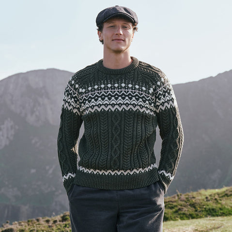 Men's Fair Isle Cable Knit Sweater in army green, crafted with authentic cable knit textures and traditional Fair Isle motifs, combining classic Irish-inspired knitwear with timeless outdoor style in a scenic countryside setting.