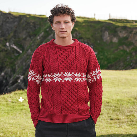 Image featuring the Men's Crew Neck Aran Christmas Sweater in red, crafted with authentic Irish Aran cable knit textures and a festive snowflake Fair Isle pattern, combining traditional Irish craftsmanship with classic holiday style.