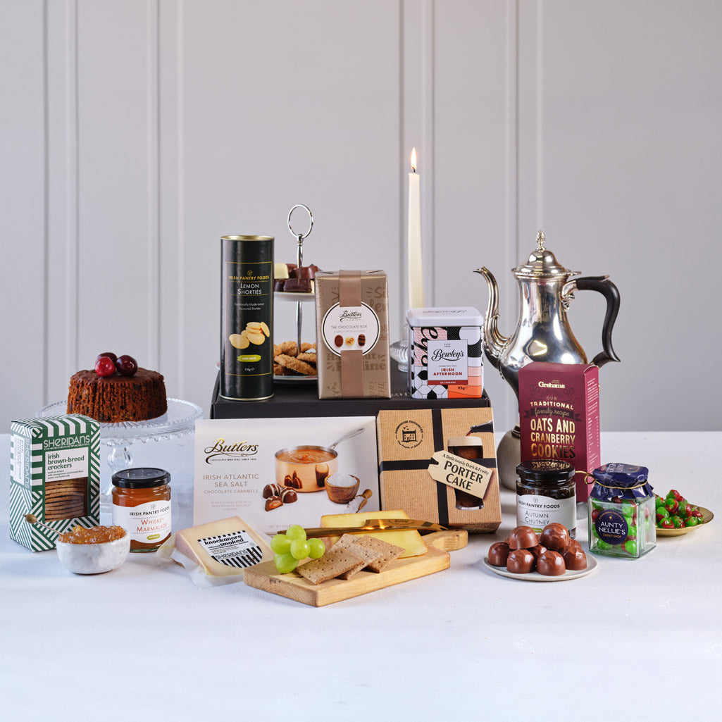 Irish Gourmet Delights Gift Basket featuring Bewley’s Irish Afternoon Tea, Butlers Sea Salt Caramels, traditional Irish fruit cake, Irish oat and cranberry cookies, Sheridan’s crackers, Ballymaloe relish, Irish cheese, chocolates, and sweet treats.