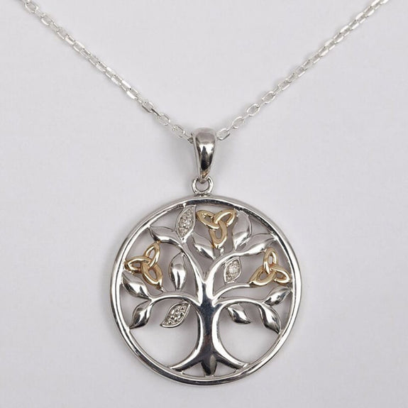 Silver pendant necklace featuring a tree of life design with intricate branches, set within a circular frame. The pendant hangs from a delicate chain.