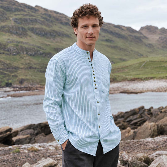 Image featuring the Green Stripe Grandad Shirt, crafted with a traditional Irish grandad collar, classic green and white stripe design, button-front placket, and relaxed fit, showcasing timeless Irish style against a scenic coastal landscape.