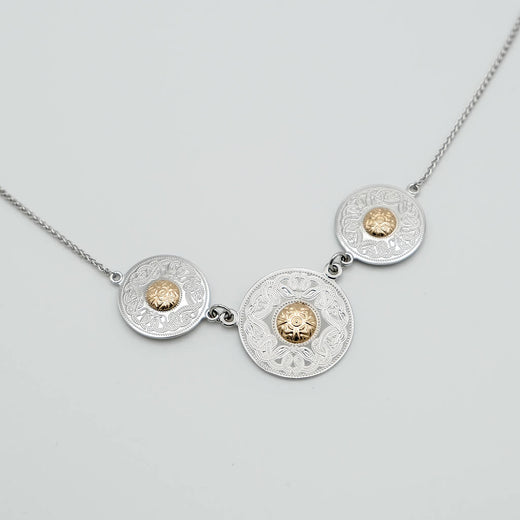 Necklace with three circular medallions featuring gold centers on a light gray background