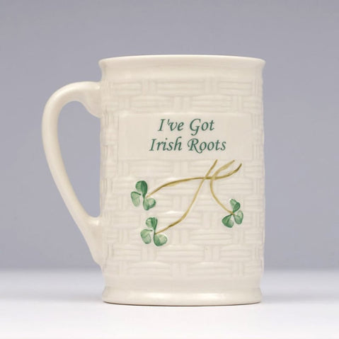 Cream Belleek mug featuring a woven‑style texture with green shamrocks and the text “I’ve Got Irish Roots” on the front.
