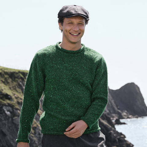 Men's Traditional Fisherman Irish Wool Sweater in Valley Green, crafted from premium Irish wool with an authentic fisherman knit texture, styled along the rugged Irish coastline with dramatic cliffs and ocean views.