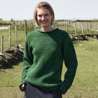 Women's Traditional Fisherman Irish Wool Sweater in Valley Green, crafted from premium Irish wool with authentic fisherman knit texture, styled in the Irish countryside with rolling green fields and traditional rural scenery.
