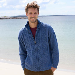Man wearing a denim  Men's Signature Lined Fisherman Zipper Cardigan by a body of water