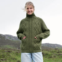 Image featuring the Women's Hand Knit Aran Zipper Cardigan in green, crafted with authentic Irish Aran cable knit patterns, a full-zip fastening, and a high ribbed collar, showcasing traditional Irish craftsmanship in a scenic countryside setting.