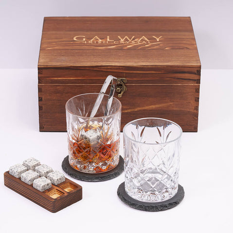 Galway Crystal Renmore wooden whiskey gift set featuring two cut‑crystal glasses, whiskey stones with a wooden holder, and a wooden gift box in the background.