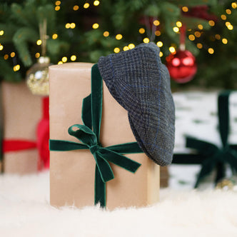 Wrapped gift boxes with velvet ribbons in front of a decorated Christmas tree with bokeh lights