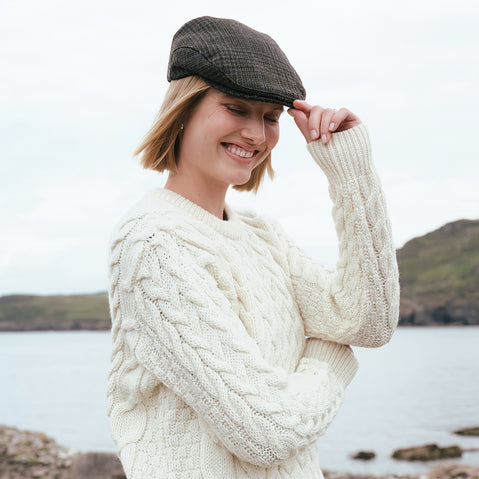 Women's Heritage Plaid Irish Flat Cap Green Check with traditional Irish Aran sweater by the Irish coast.