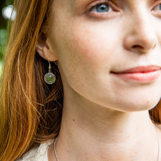 Close-up of a woman wearing a green earring outdoors