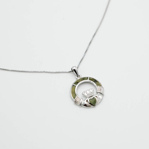 Silver Claddagh pendant with green stone on a white background